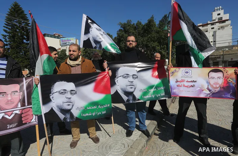Palestinian Journalists hold pictures of journalist Mohammed al-Qeq, who has been on a hunger strike in an Israeli jail for 65 days, during a protest to show solidarity with him, in Gaza city January 28, 2016. Qeq went o...