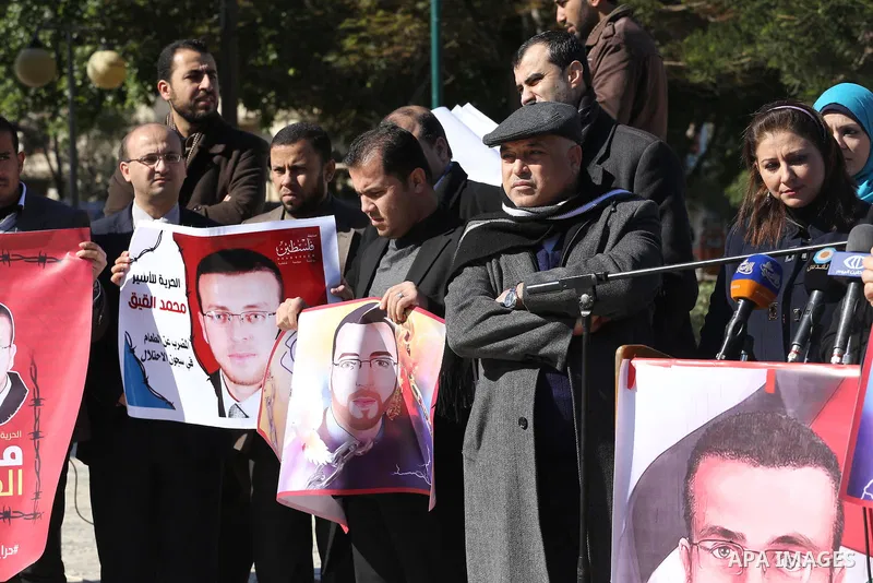 Palestinian Journalists hold pictures of journalist Mohammed al-Qeq, who has been on a hunger strike in an Israeli jail for 65 days, during a protest to show solidarity with him, in Gaza city January 28, 2016. Qeq went o...