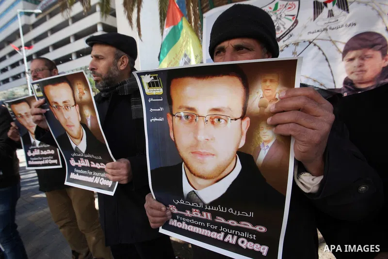 Palestinians hold pictures of journalist Mohammed al-Qeq, who has been on a hunger strike in an Israeli jail for 65 days, during a protest to show solidarity with him, in the West bank city of Nablus, on January 28, 2016...