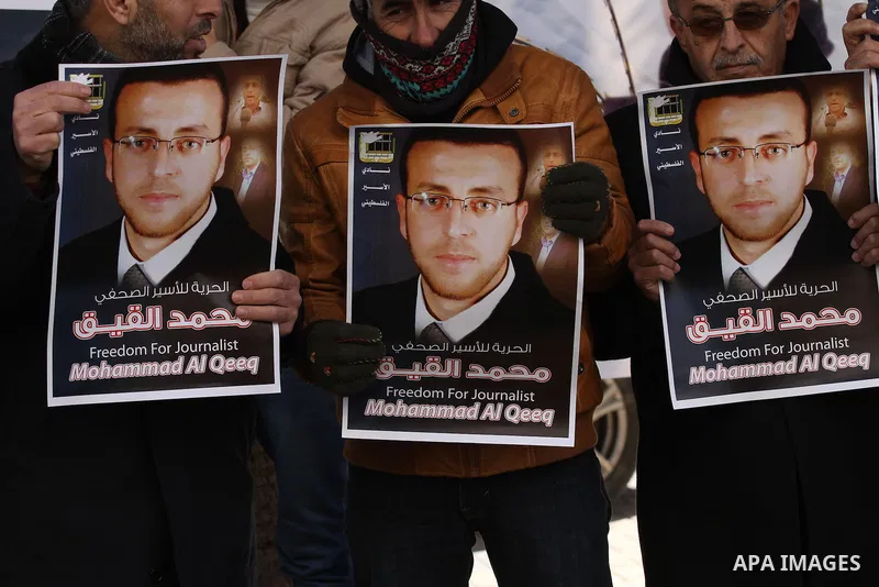 Palestinians hold pictures of journalist Mohammed al-Qeq, who has been on a hunger strike in an Israeli jail for 65 days, during a protest to show solidarity with him, in the West bank city of Nablus, on January 28, 2016...