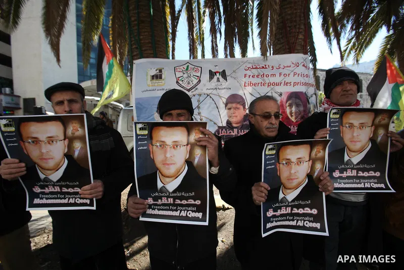 Palestinians hold pictures of journalist Mohammed al-Qeq, who has been on a hunger strike in an Israeli jail for 65 days, during a protest to show solidarity with him, in the West bank city of Nablus, on January 28, 2016...