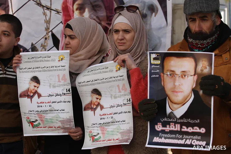 Palestinians hold pictures of journalist Mohammed al-Qeq, who has been on a hunger strike in an Israeli jail for 65 days, during a protest to show solidarity with him, in the West bank city of Nablus, on January 28, 2016...