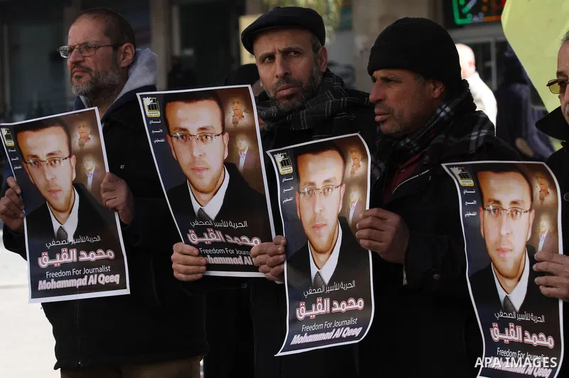 Palestinians hold pictures of journalist Mohammed al-Qeq, who has been on a hunger strike in an Israeli jail for 65 days, during a protest to show solidarity with him, in the West bank city of Nablus, on January 28, 2016...