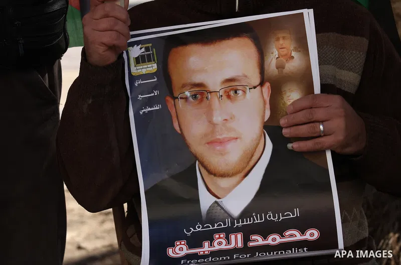 Palestinians hold pictures of journalist Mohammed al-Qeq, who has been on a hunger strike in an Israeli jail for 65 days, during a protest to show solidarity with him, in the West bank city of Nablus, on January 28, 2016...