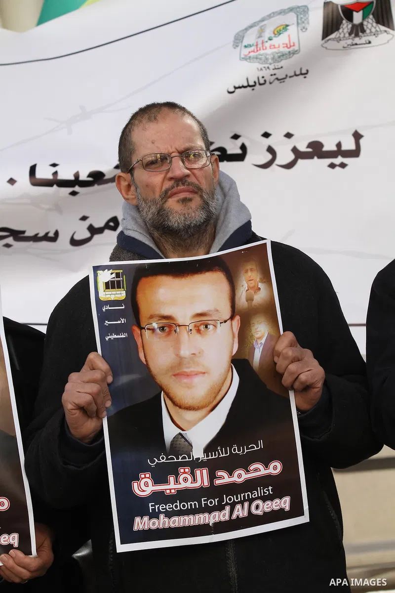 Palestinians hold pictures of journalist Mohammed al-Qeq, who has been on a hunger strike in an Israeli jail for 65 days, during a protest to show solidarity with him, in the West bank city of Nablus, on January 28, 2016...