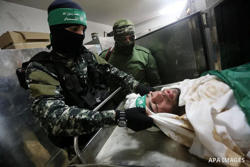Palestinian Hamas militants look at the bodies of Hamas militants killed after a tunnel, built for fighting Israel, collapsed in the Gaza Strip, at the morgue in the al-Shifa hospital in Gaza City on January 29, 2016. Se...