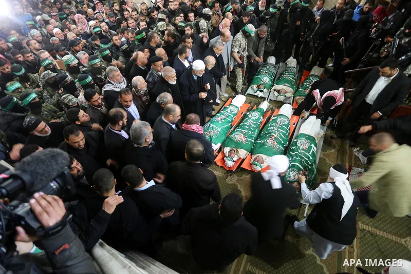 Palestinians pray at a mosque near the bodies of the seven Palestinian Hamas militants whom killed after a tunnel, built for fighting Israel, collapsed in the Gaza Strip, during their funeral in Gaza City on January 29,...