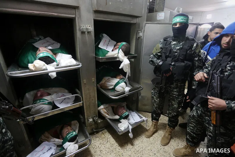 Palestinian Hamas militants look at the bodies of Hamas militants killed after a tunnel, built for fighting Israel, collapsed in the Gaza Strip, at the morgue in the al-Shifa hospital in Gaza City on January 29, 2016. Se...