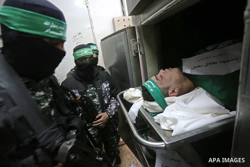 Palestinian Hamas militants look at the bodies of Hamas militants killed after a tunnel, built for fighting Israel, collapsed in the Gaza Strip, at the morgue in the al-Shifa hospital in Gaza City on January 29, 2016. Se...