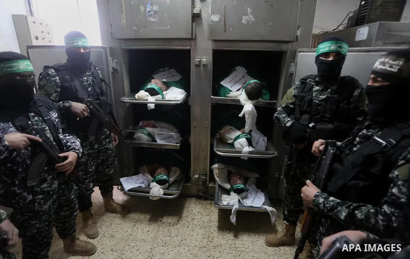 Palestinian Hamas militants look at the bodies of Hamas militants killed after a tunnel, built for fighting Israel, collapsed in the Gaza Strip, at the morgue in the al-Shifa hospital in Gaza City on January 29, 2016. Se...