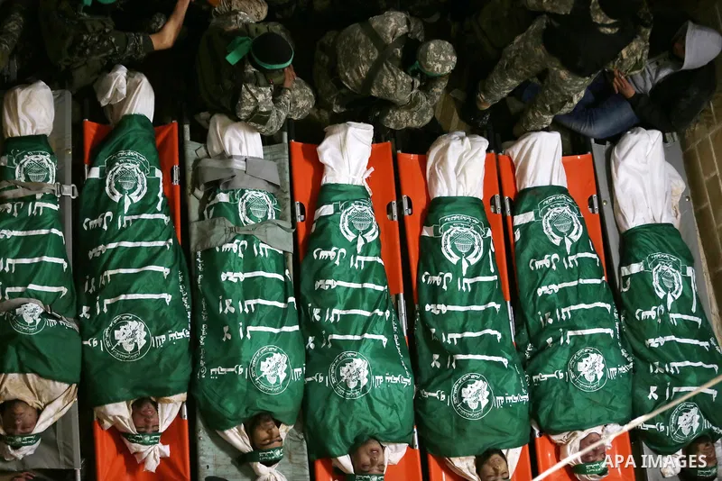 Palestinian Hamas militants and mourners gather around the bodies of seven Hamas militants killed after a tunnel, built for fighting Israel, collapsed in the Gaza Strip, during their funeral in Gaza City on January 29, 2...