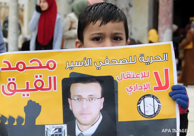 Palestinians hold posters bearing a portrait of Palestinian journalist Mohammed al-Qiq who is imprisoned in an Israeli jail during a protest in support of his hunger strike in front of Jerusalem's Dome of the Rock mosque...