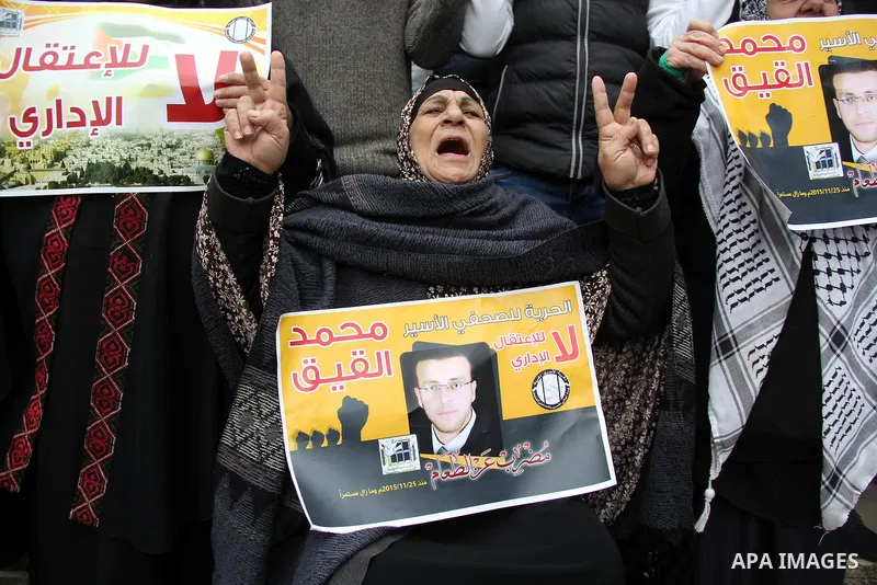 Palestinians hold posters bearing a portrait of Palestinian journalist Mohammed al-Qiq who is imprisoned in an Israeli jail during a protest in support of his hunger strike in front of Jerusalem's Dome of the Rock mosque...