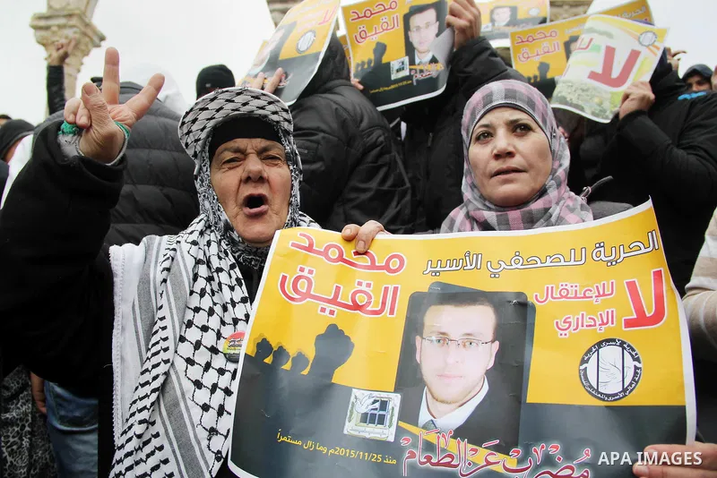 Palestinians hold posters bearing a portrait of Palestinian journalist Mohammed al-Qiq who is imprisoned in an Israeli jail during a protest in support of his hunger strike in front of Jerusalem's Dome of the Rock mosque...