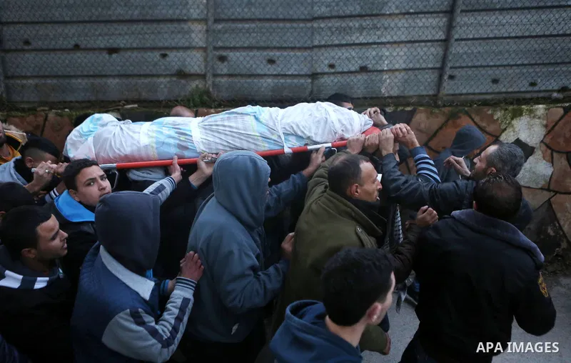 Palestinian men carry a body of a Palestinian alleged attacker Hussein Abu Ghush, 17, upon its release by the Israeli security forces in the West Bank city of Ramallah, on Jan 29, 2016. Israeli authorities announced on T...