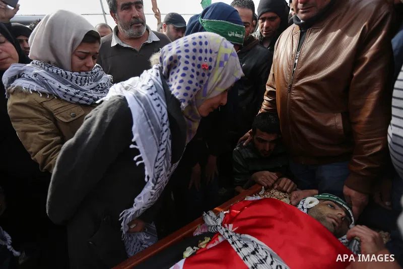 Relatives mourn over the body of a Palestinian Ibrahim Allan, 22, upon its release by the Israeli security forces, during his funeral, in the West Bank city of Ramallah, on Jan 30, 2016. Israeli authorities announced on...