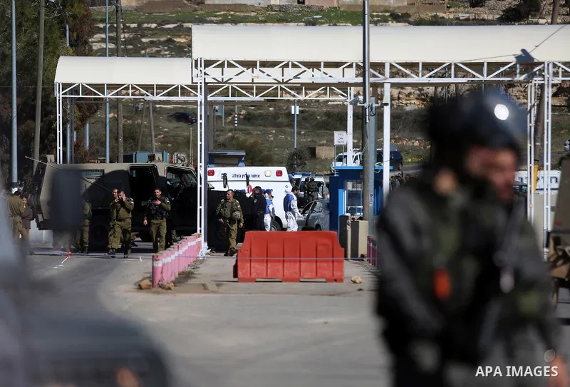 Israeli troops gather around the body of a dead Palestinian assailant at the scene of a shooting attack at an Israeli military checkpoint near the West Bank city of Ramallah January 31, 2016. Photo by Shadi Hatem