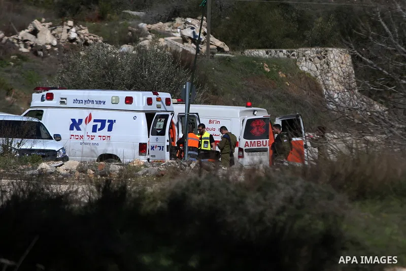 Israeli troops gather around the body of a dead Palestinian assailant at the scene of a shooting attack at an Israeli military checkpoint near the West Bank city of Ramallah January 31, 2016. Photo by Shadi Hatem