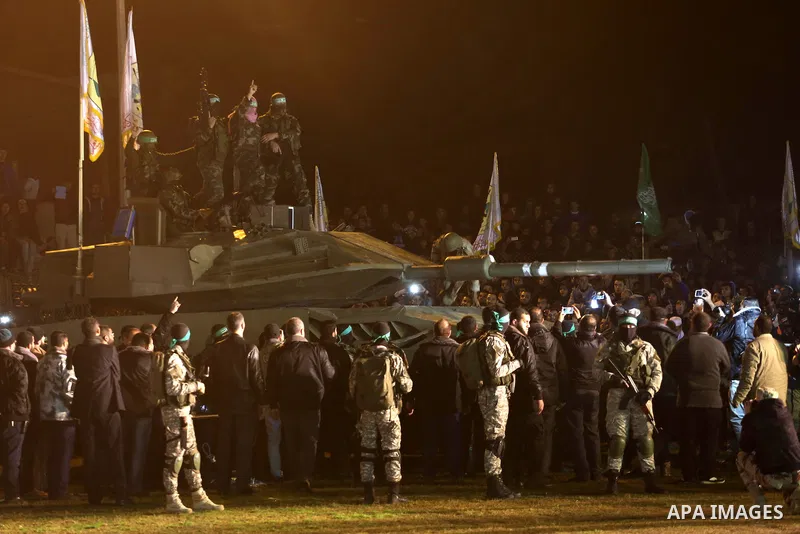 Palestinian members of the Ezzedine al-Qassam Brigades, the armed wing of the Hamas movement, gather around a mock Israeli tank on January 31, 2016 in Gaza city during a gathering to pay tribute to the brigade's militant...