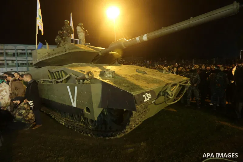 Palestinian members of the Ezzedine al-Qassam Brigades, the armed wing of the Hamas movement, gather around a mock Israeli tank on January 31, 2016 in Gaza city during a gathering to pay tribute to the brigade's militant...