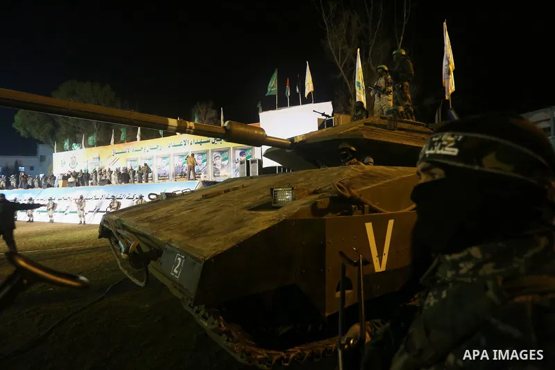Palestinian members of the Ezzedine al-Qassam Brigades, the armed wing of the Hamas movement, gather around a mock Israeli tank on January 31, 2016 in Gaza city during a gathering to pay tribute to the brigade's militant...