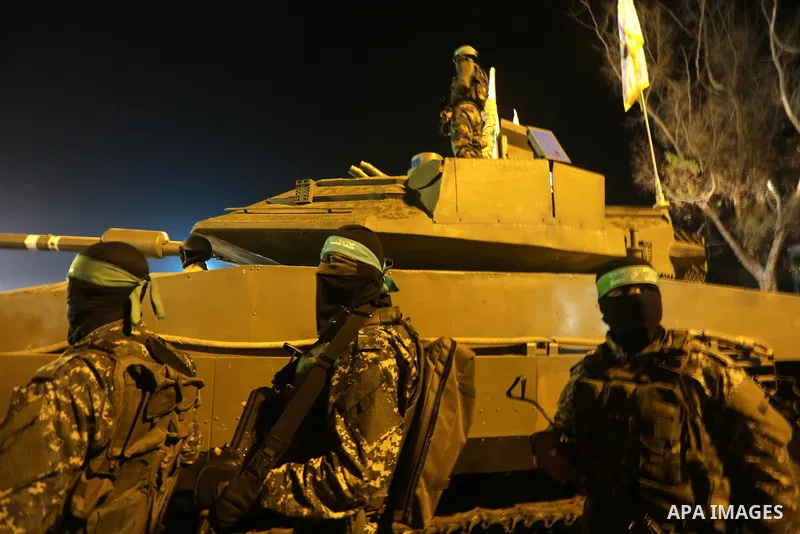 Palestinian members of the Ezzedine al-Qassam Brigades, the armed wing of the Hamas movement, gather around a mock Israeli tank on January 31, 2016 in Gaza city during a gathering to pay tribute to the brigade's militant...