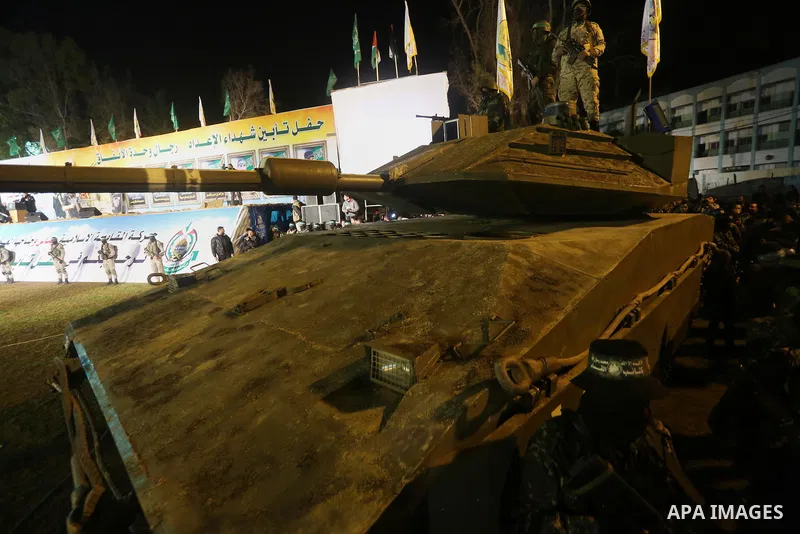 Palestinian members of the Ezzedine al-Qassam Brigades, the armed wing of the Hamas movement, gather around a mock Israeli tank on January 31, 2016 in Gaza city during a gathering to pay tribute to the brigade's militant...