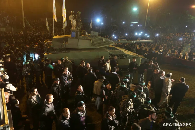 Palestinian members of the Ezzedine al-Qassam Brigades, the armed wing of the Hamas movement, gather around a mock Israeli tank on January 31, 2016 in Gaza city during a gathering to pay tribute to the brigade's militant...