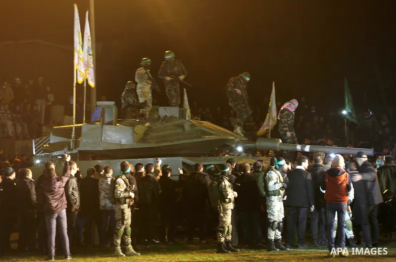 Palestinian members of the Ezzedine al-Qassam Brigades, the armed wing of the Hamas movement, gather around a mock Israeli tank on January 31, 2016 in Gaza city during a gathering to pay tribute to the brigade's militant...