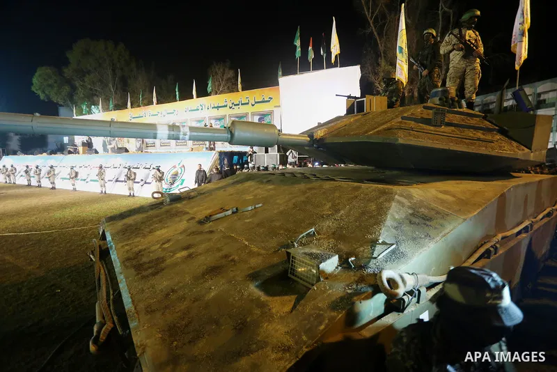 Palestinian members of the Ezzedine al-Qassam Brigades, the armed wing of the Hamas movement, gather around a mock Israeli tank on January 31, 2016 in Gaza city during a gathering to pay tribute to the brigade's militant...