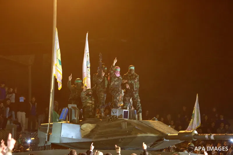 Palestinian members of the Ezzedine al-Qassam Brigades, the armed wing of the Hamas movement, gather around a mock Israeli tank on January 31, 2016 in Gaza city during a gathering to pay tribute to the brigade's militant...