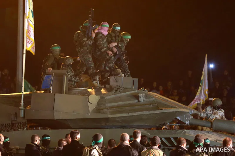 Palestinian members of the Ezzedine al-Qassam Brigades, the armed wing of the Hamas movement, gather around a mock Israeli tank on January 31, 2016 in Gaza city during a gathering to pay tribute to the brigade's militant...