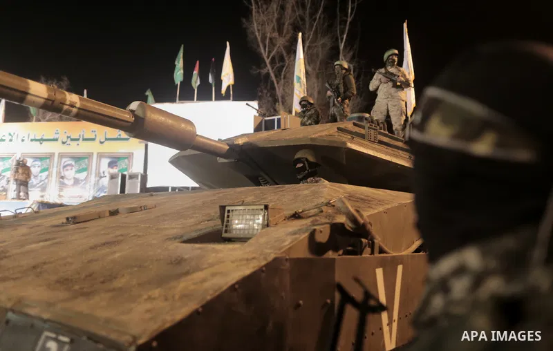 Palestinian members of the Ezzedine al-Qassam Brigades, the armed wing of the Hamas movement, gather around a mock Israeli tank on January 31, 2016 in Gaza city during a gathering to pay tribute to the brigade's militant...