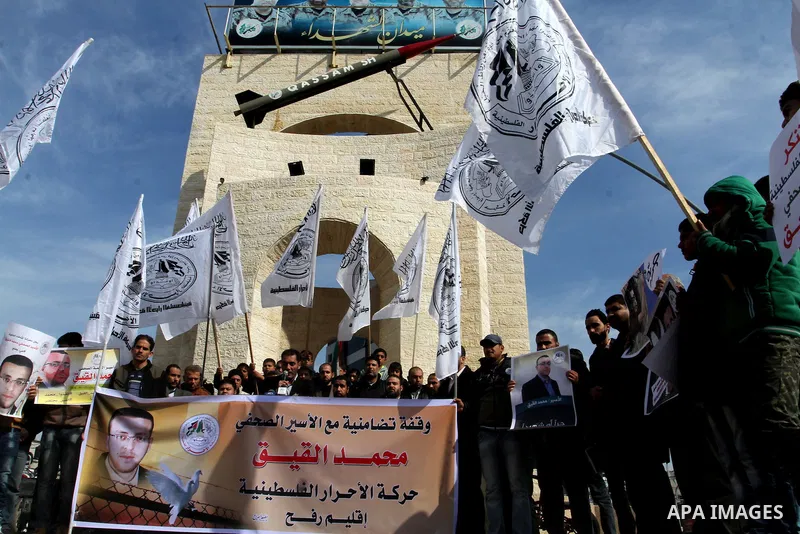 Palestinians hold posters bearing a portrait of Palestinian journalist Mohammed al-Qiq who is imprisoned in an Israeli jail during a protest in support of his hunger strike in rafah in the southern Gaza strip, on Feb. 01...