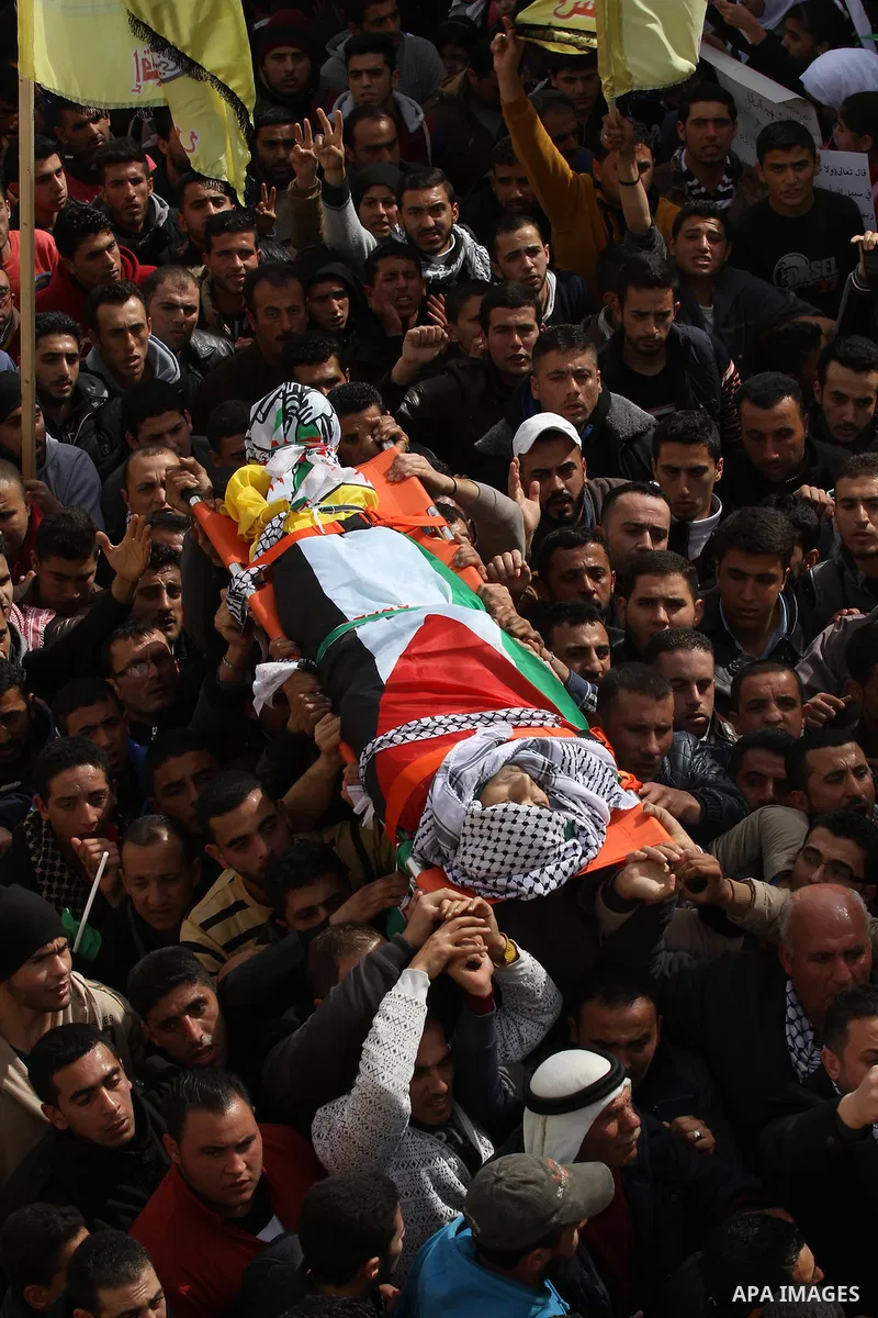 Mourners carry the body of Palestinian gunman Amjad Abu Omar, whom the Israeli army said was shot dead by soldiers after he wounded three Israelis on Sunday, during his funeral in the West Bank village of Jamain near Nab...