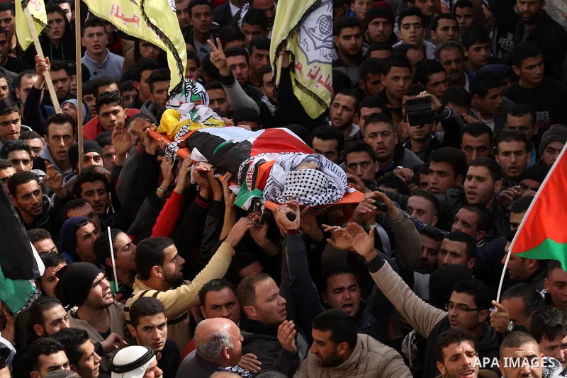 Mourners carry the body of Palestinian gunman Amjad Abu Omar, whom the Israeli army said was shot dead by soldiers after he wounded three Israelis on Sunday, during his funeral in the West Bank village of Jamain near Nab...