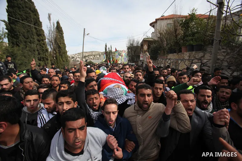 Mourners carry the body of Palestinian gunman Amjad Abu Omar, whom the Israeli army said was shot dead by soldiers after he wounded three Israelis on Sunday, during his funeral in the West Bank village of Jamain near Nab...