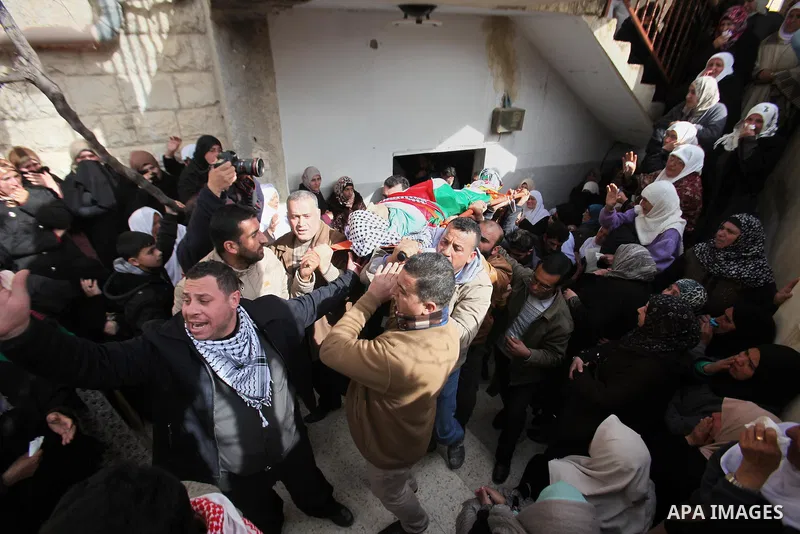 Mourners carry the body of Palestinian gunman Amjad Abu Omar, whom the Israeli army said was shot dead by soldiers after he wounded three Israelis on Sunday, during his funeral in the West Bank village of Jamain near Nab...
