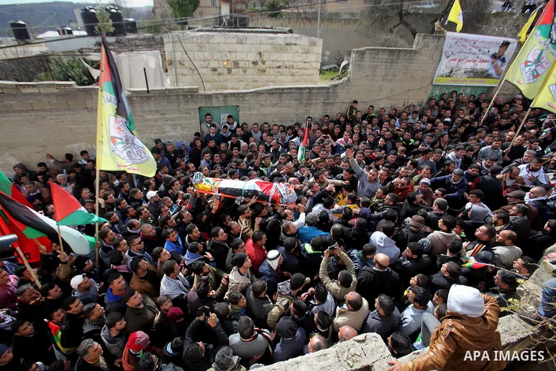 Mourners carry the body of Palestinian gunman Amjad Abu Omar, whom the Israeli army said was shot dead by soldiers after he wounded three Israelis on Sunday, during his funeral in the West Bank village of Jamain near Nab...