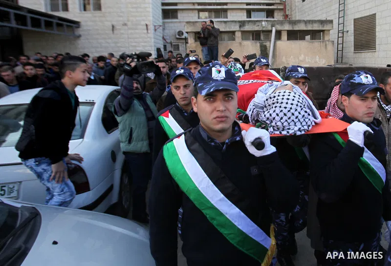 Palestinian policemen carry the body of Palestinian gunman Amjad Abu Omar, whom the Israeli army said was shot dead by soldiers after he wounded three Israelis on Sunday, during his funeral in the West Bank village of Ja...