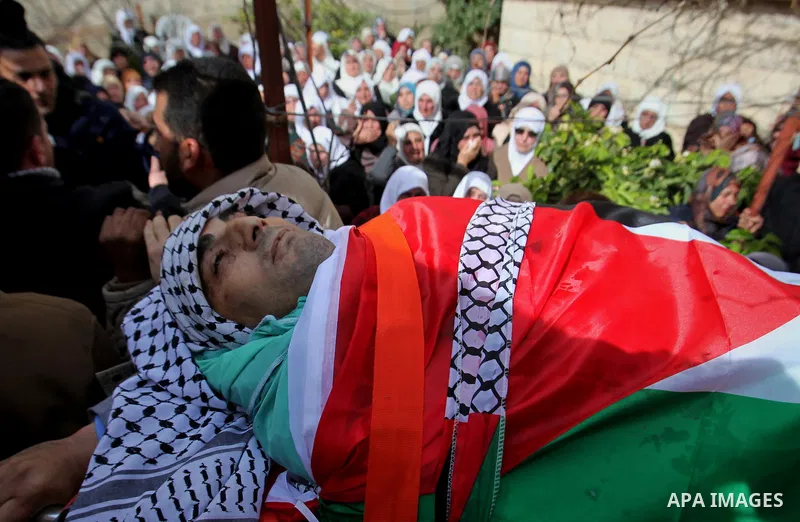 Mourners carry the body of Palestinian gunman Amjad Abu Omar, whom the Israeli army said was shot dead by soldiers after he wounded three Israelis on Sunday, during his funeral in the West Bank village of Jamain near Nab...