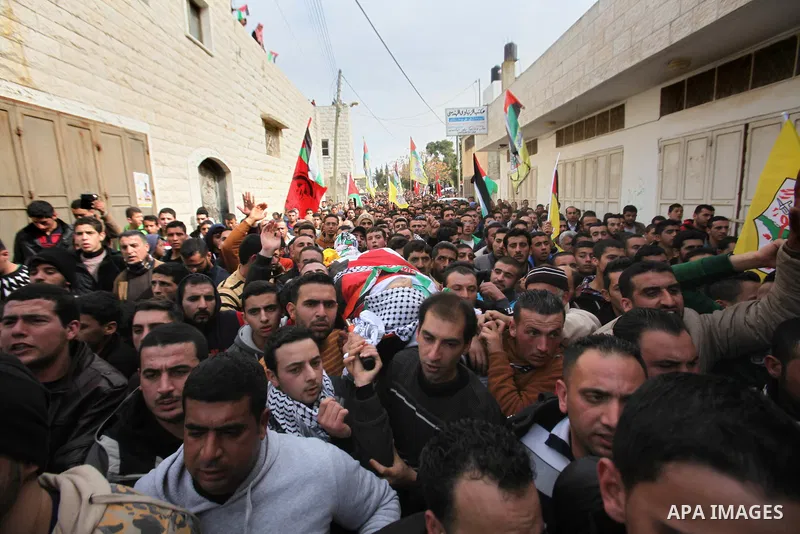Mourners carry the body of Palestinian gunman Amjad Abu Omar, whom the Israeli army said was shot dead by soldiers after he wounded three Israelis on Sunday, during his funeral in the West Bank village of Jamain near Nab...