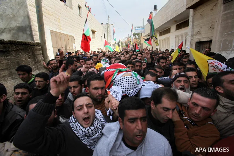 Mourners carry the body of Palestinian gunman Amjad Abu Omar, whom the Israeli army said was shot dead by soldiers after he wounded three Israelis on Sunday, during his funeral in the West Bank village of Jamain near Nab...