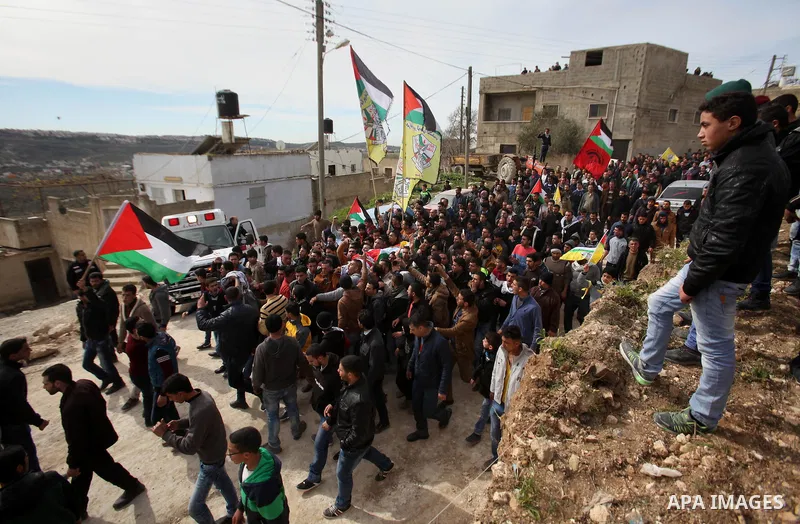 Mourners carry the body of Palestinian gunman Amjad Abu Omar, whom the Israeli army said was shot dead by soldiers after he wounded three Israelis on Sunday, during his funeral in the West Bank village of Jamain near Nab...