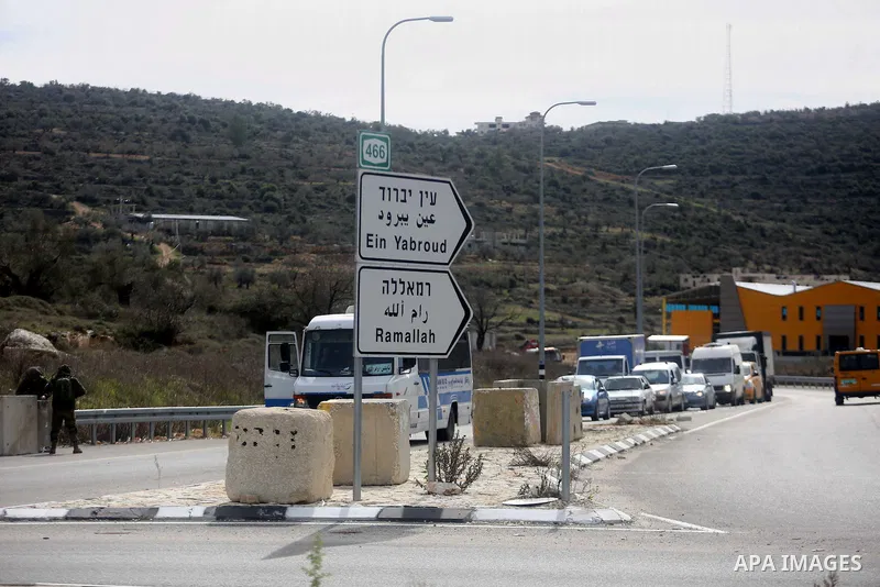 An Israeli soldier stands guard as he checks Palestinians' vehicles on their way out of the West Bank village of Ein Sinya, northern Ramallah on February 1, 2016. Israel blocked non-residents from Ramallah after a checkp...