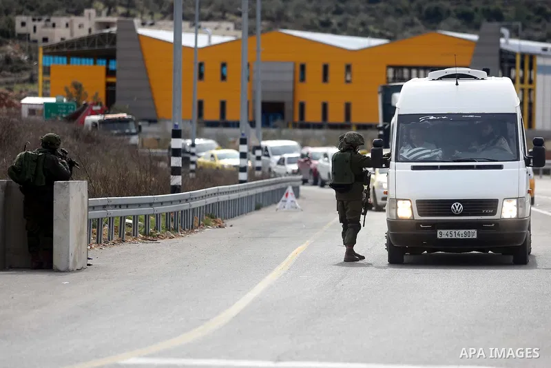 An Israeli soldier checks the documents of passengers of a Palestinian car on their way out of the West Bank village of Ein Sinya, northern Ramallah on February 1, 2016. Israel blocked non-residents from Ramallah after a...