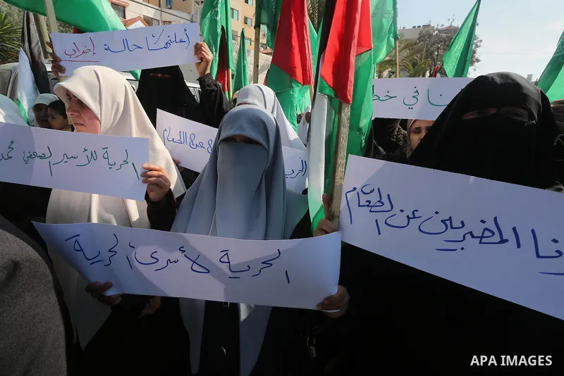 Palestinian women hold banners during a protest to show solidarity with journalist Mohammed al-Qiq who is imprisoned in an Israeli jail, Gaza city, on February 02, 2016. Photo by Mohammed Asad