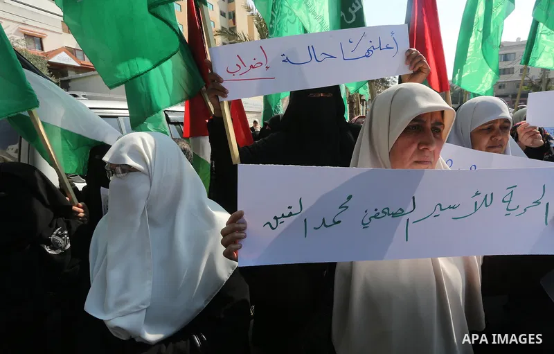 Palestinian women hold banners during a protest to show solidarity with journalist Mohammed al-Qiq who is imprisoned in an Israeli jail, Gaza city, on February 02, 2016. Photo by Mohammed Asad