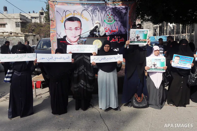 Palestinian women hold banners during a protest to show solidarity with journalist Mohammed al-Qiq who is imprisoned in an Israeli jail, Gaza city, on February 02, 2016. Photo by Mohammed Asad