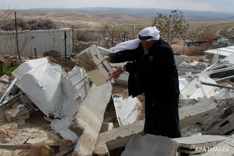 A Palestinian man collects items from his home after it was demolished by Israeli bulldozers in a disputed military zone in the area of Musafir Jenbah, which includes several villages, south of the West Bank town of Hebr...
